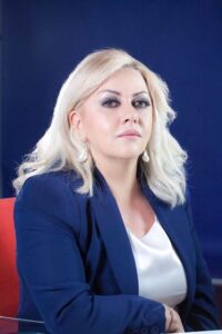 Rosaria Carfagna, Presidente della Fondazione MIdA. Ritratto fotografico a mezzo busto: ha capelli biondi, indossa una giacca blu su una camicetta bianca e orecchini di perla.